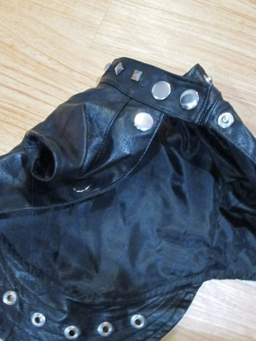 Small faux black leather studded doggie motorcycle jacket modeled by a rockstar